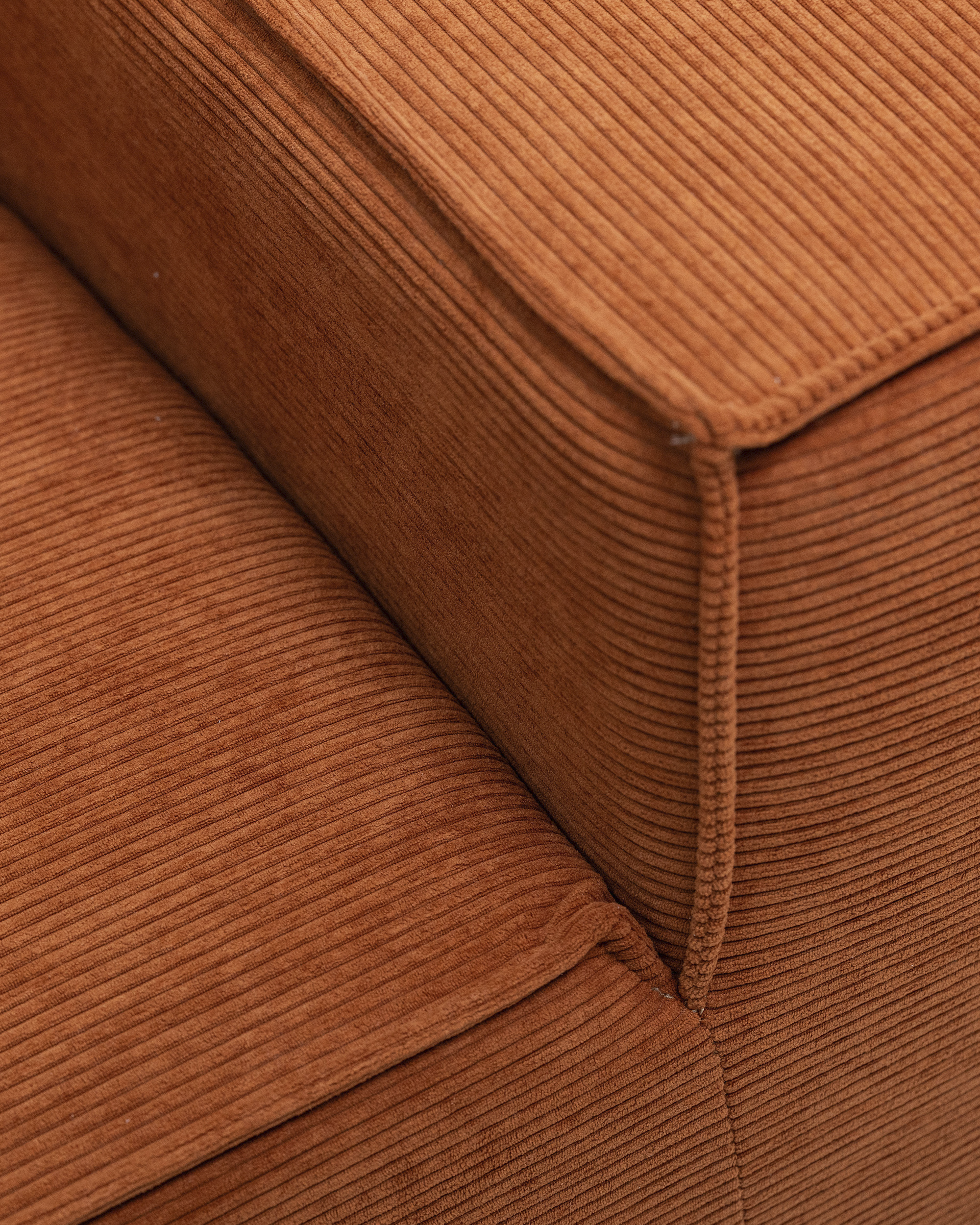 Brel 2-Seater Sofa close-up in orange ribbed fabric upholstery