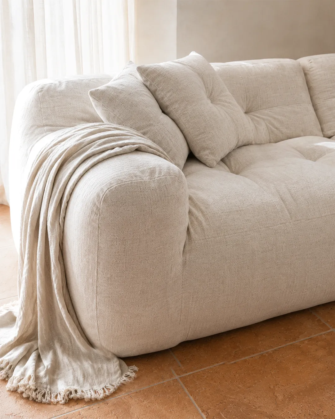 Detail of Marley 2-Seater Modular Sofa armrest and seat in textured off-white fabric upholstery