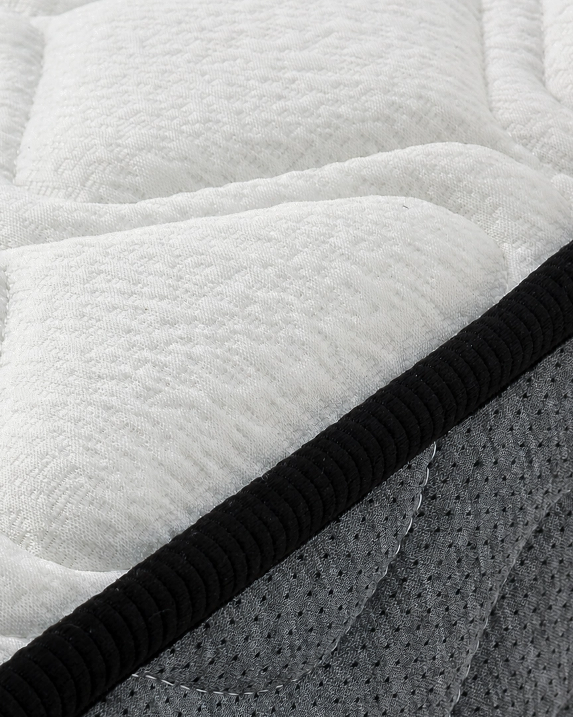 Tina Mattress close-up with white textured fabric and gray perforated side panel