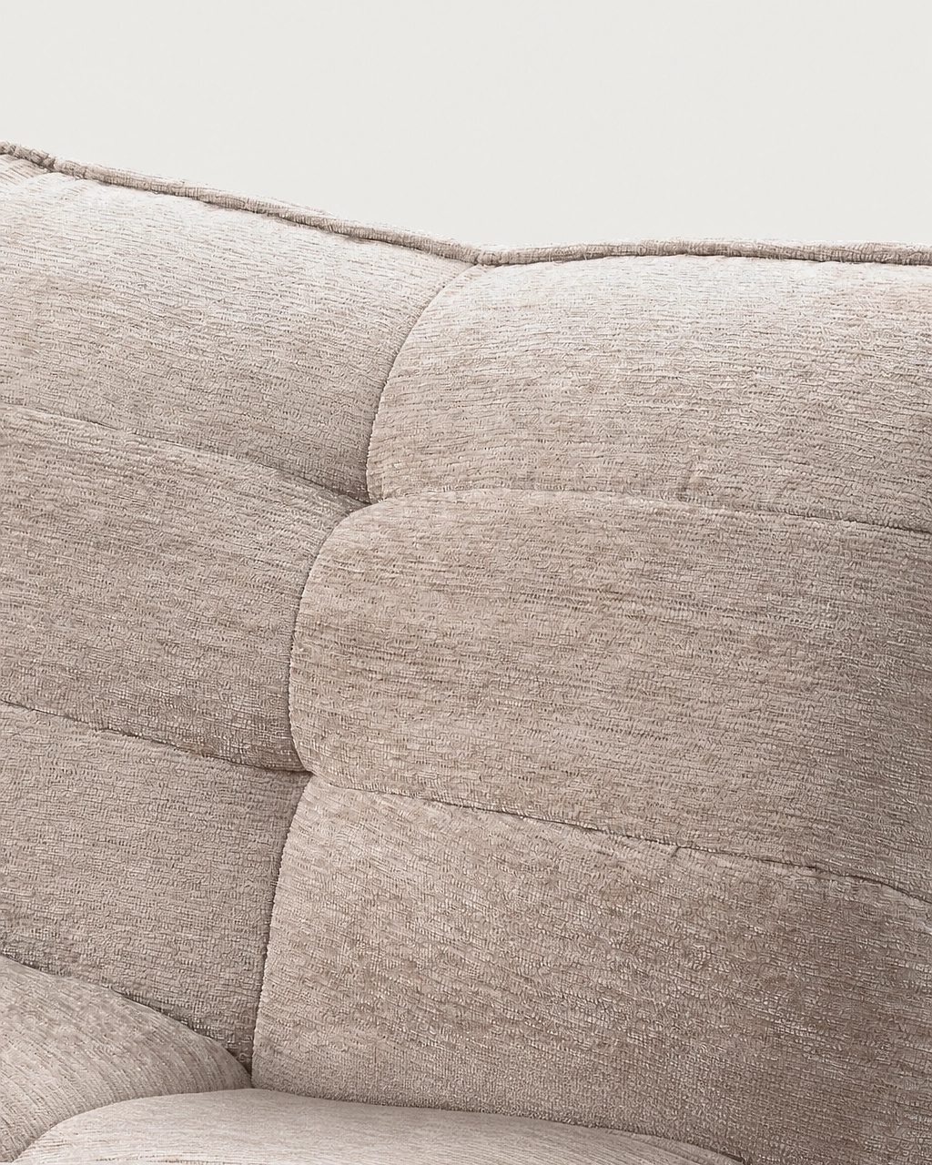 Zeca Upholstered Armchair in textured sand beige fabric, showing cushioned back and armrest